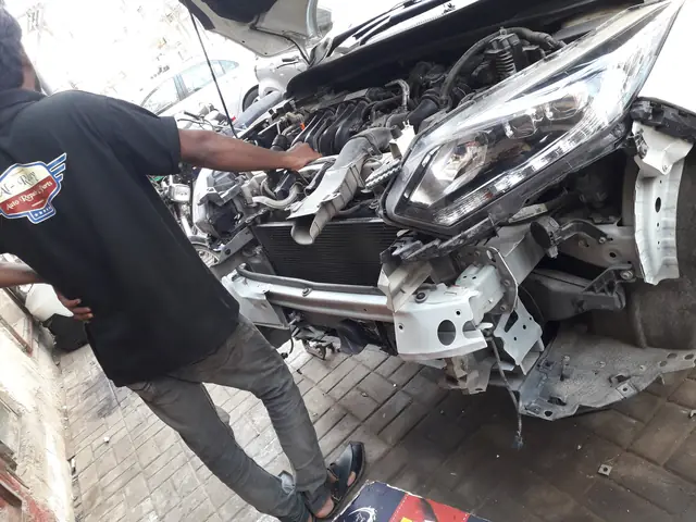Car with its front bumper and grille removed for body denting work