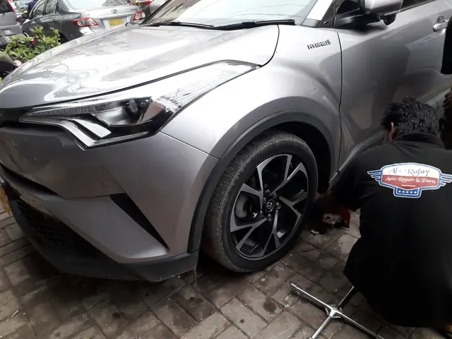 Toyota C-HR raised on a stand with the front wheel off for suspension work